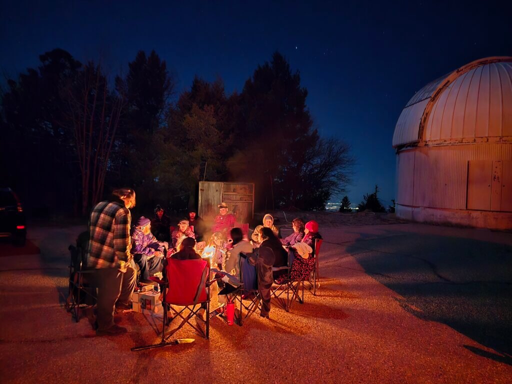 Students from Edge High School sit around an outdoor campfire at University of Arizona Sky School.
