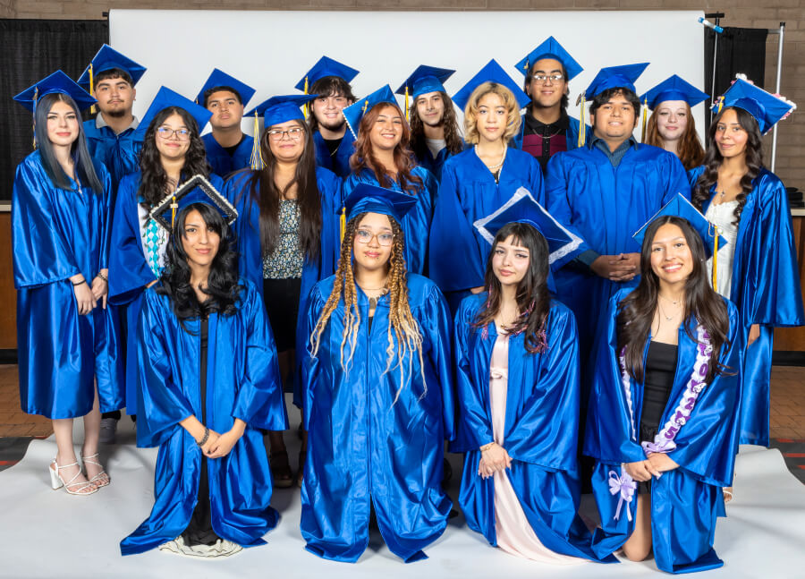 A group of Edge High School graduates pose for a photo in blue caps and gowns