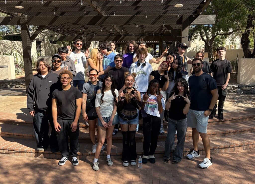 Edge High School's math teacher, Juan Chouza stands outside with a group of Edge students for a photo.